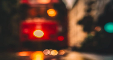 Straßenbahn bei Nacht und Spiegelungen auf der Straße: verschwommene Darstellung – Visualisierung von Barrieren im Web aufgrund von Behinderungen